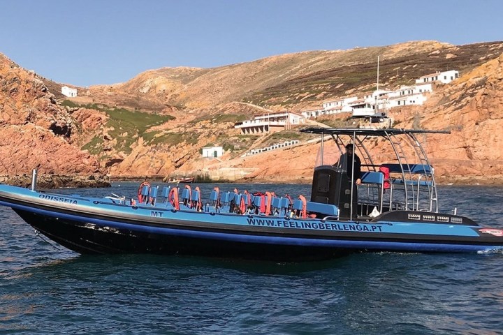 a small boat in a body of water with a mountain in the background