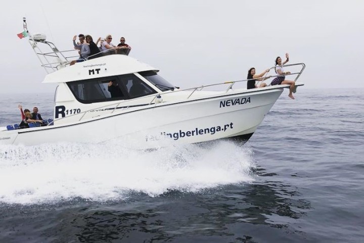 a group of people riding on the back of a boat in the water